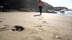 Unrecognizable woman walking at the beach barefoot leaving footprints on sand Stock Footage