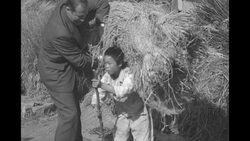 Economic Cooperation Administration head Foster helps boy carry straw during on inspection tour in South Korea News Clip