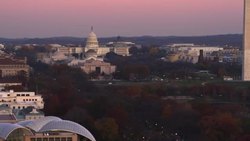 Flying by United States Institute of Peace, over Foggy Bottom and Constitution Avenue, past Constitution Gardens Pond and West Potomac Park toward the National Mall at dusk; Smithsonian Museum of Natural History (with dark doors) at left. Shot in 2011. Stock Footage