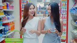 Two young women shopping and using smartphone in supermarket,Slow motion Stock Footage