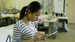 Asian Seamstress Browsing Internet with Tablet Stock Footage