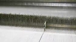 White Threads on a loom in weaving loom machine in textile factory Stock Footage
