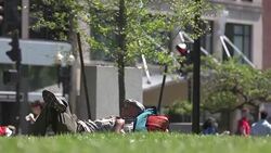 Man lying in city green space Stock Footage
