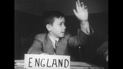 United States, 1950s: Boy reads from card, sits at desk with 'India' label Stock Footage