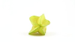 One whole carambola fruit rotating on the turntable isolated on the white background. Close up. Macro. Stock Footage