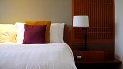 White comfortable pillow with light lamp decoration in bedroom interior Stock Footage