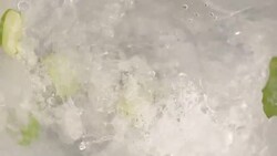 Lemon slice and mint into water swirling slow motion Stock Footage