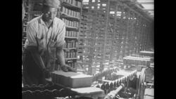 1940s: Bricks on conveyor belt, kids watching in foreground Stock Footage