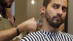 Trendy man getting his haircut by barber Stock Footage