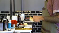 Barber cleaning electric razor with brush in shop Stock Footage