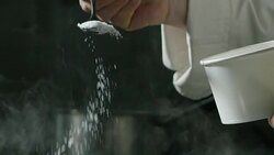 in an Italian professional kitchen a chef pours salt on a dish or in the water to boil the Italian pasta concept of healthy and light food. Stock Footage