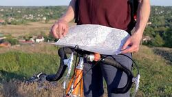 Cyclist in a mountainous area with a map Stock Footage