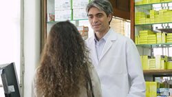 Customer talking to male chemist at pharmacy Stock Footage