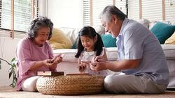 Senior man woman and little girl playing board game together at home. people with family, lifestyle, education concept. 4k resolution. Stock Footage