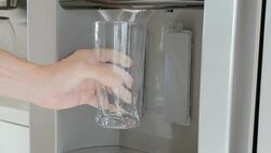 pouring ice cubes from a fridge door into a glass Stock Footage