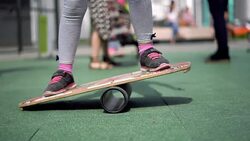 life in a modern city - a girl rides a balance-board on an advanced playground Stock Footage