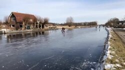 CLEAN : Dutch people riding a motorcycle on a frozen canal in Leidschendam News Clip