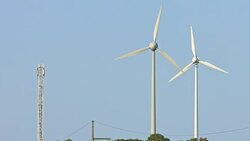 Wind turbines and agricultural fields on a summer day Stock Footage