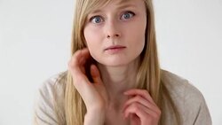 beautiful long-haired girl of European appearance with blond hair looks at her face closeup Stock Footage