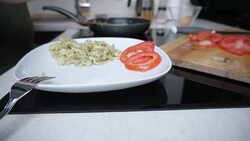 Hands of young man sprinkling black pepper on scrambled eggs and tomato slices Stock Footage