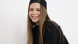 teenage girl in trendy hip hop clothes and cap posing against white wall Stock Footage