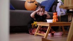 Asian baby girl with pumpkin toy while eating and singing song with mother at home Stock Footage