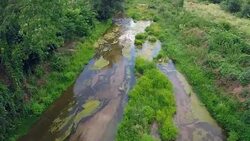 Aerial view of small river and a bridge - Stock Video Stock Footage