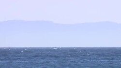 A Wide shot of a boat crashing against the waves near Atlanterra Beach News Clip