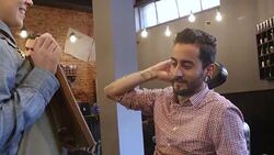 Customer checking hairstyle and beard in salon Stock Footage