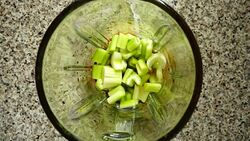 Mentha leaves fall on stalk of an apium in a blender bowl. Slow motion.	Top view. Stock Footage