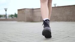 Close shot of female legs walking in heavy army boots. Closeup shooting fashionable female in leather boots walk in street on stone Stock Footage