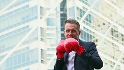 Handsome young businessman punching with boxing gloves. concept of business competition. Stock Footage