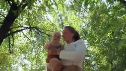 Mother Holding Baby and Walking in Park Stock Footage