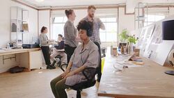 Serene creative businesswoman meditating with headphones in open office Stock Footage