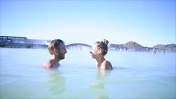 Geothermal spa. Young couple relaxing in hot spring pool in Iceland. people enjoying bathing in a blue water lagoon Icelandic tourist attraction, Video SLOW MOTION Stock Footage
