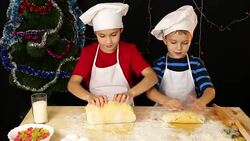 Two kids kneading the dough for christmas cookies Stock Footage