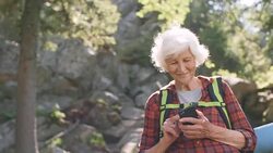 Senior Woman Typing on Smartphone in Forest Stock Footage