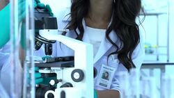 Scientist is looking through microscope with colleagues working in modern laboratory or medical center together. Concept of science, testing development and lab industry. Stock Footage