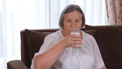 Healthy senior lady drinking a glass of fresh milk Stock Footage