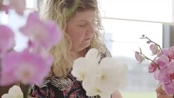 Female instructor helping active senior learning to arrange orchid flowers Stock Footage