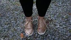 A pair of female teenage feet dance in shiny tennis shoes Stock Footage