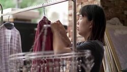 Woman hanging laundry on balcony Stock Footage