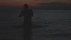 a man swims at sunset Stock Footage