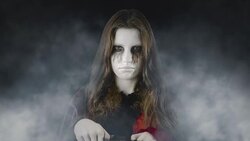 Checking the treats - teenage girl, disguised for Halloween, standing in an eerie, foggy environment Stock Footage