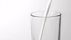 Pouring milk on white background, closeup Stock Footage