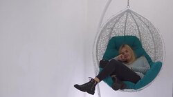 Beautiful girl thumbs a magazine in the chair Stock Footage