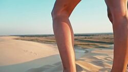 young woman enjoying the sunset on the peak of one of the desert sand dune Stock Footage