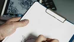 Artist or tattoo master drawing sketch on paper in front of tablet Stock Footage