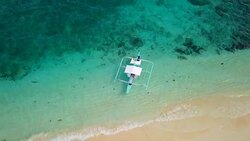 Drone shot aerial view of tropical Island and boat in turquoise pristine water. Directly above view Stock Footage