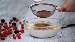 Sifting cocoa powder into a bowl. Prepare a chocolate biscuit. Baking a chocolate biscuit cake. Home confectionery. Stock Footage